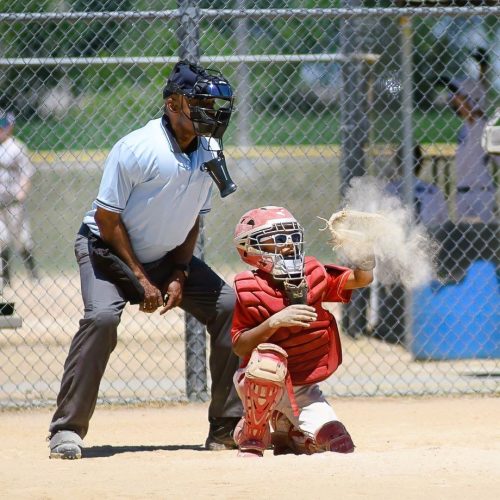 Youth baseball catcher snags ball in cloud of dust